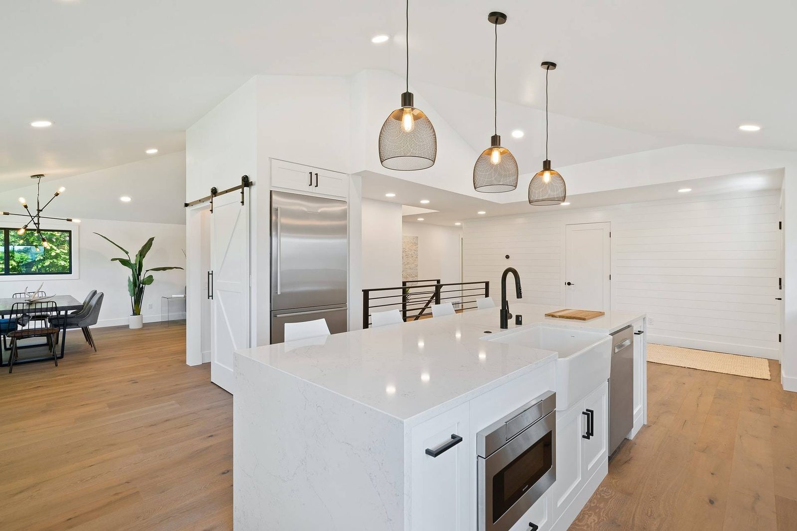 Modern white kitchen with black pendant lights (from Unsplash )